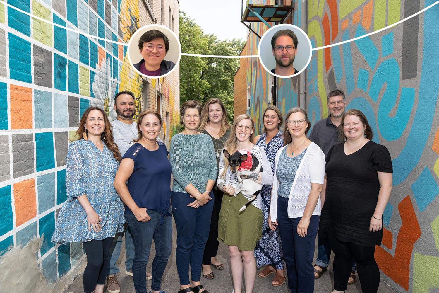 The staff of Greenleaf Media lined up posing with a dog in the alleyway